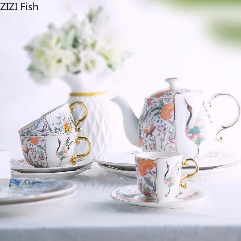 Conjunto de chá de porcelana com xícaras, pires e bule floral com detalhes dourados