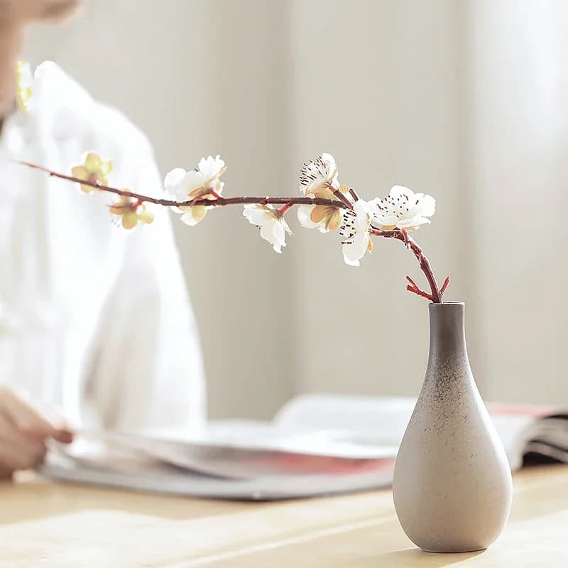 Vasos de cerâmica cinza com flores brancas e rosas, estilo retro, decoração moderna.