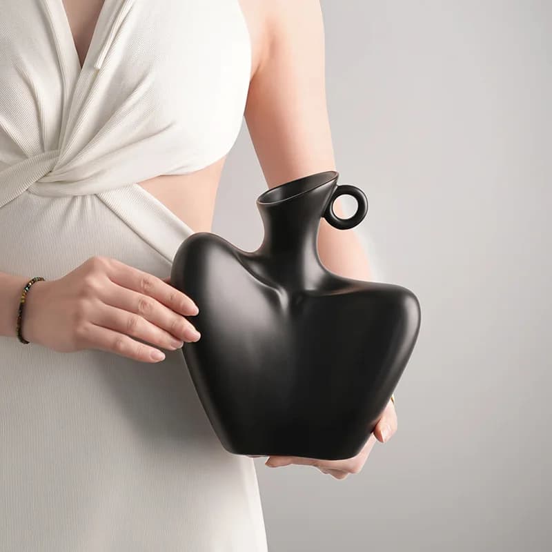 Vaso cerâmico branco e preto em forma de figura humana para decoração de interiores.