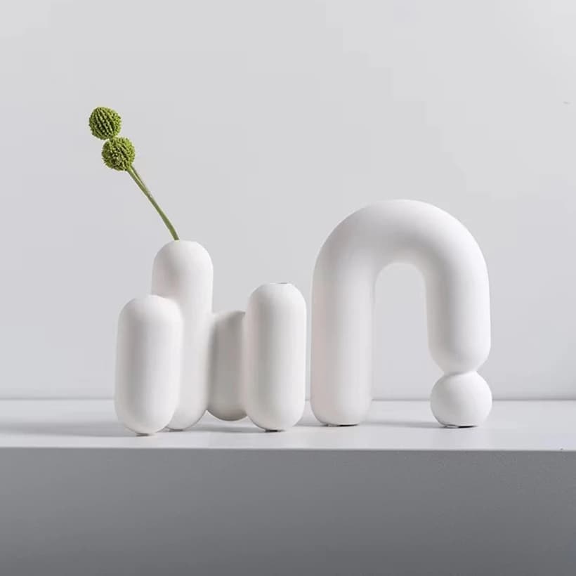 Vaso decorativo Jácotei nórdico em porcelana branca com design abstrato e flores artificiais verdes
