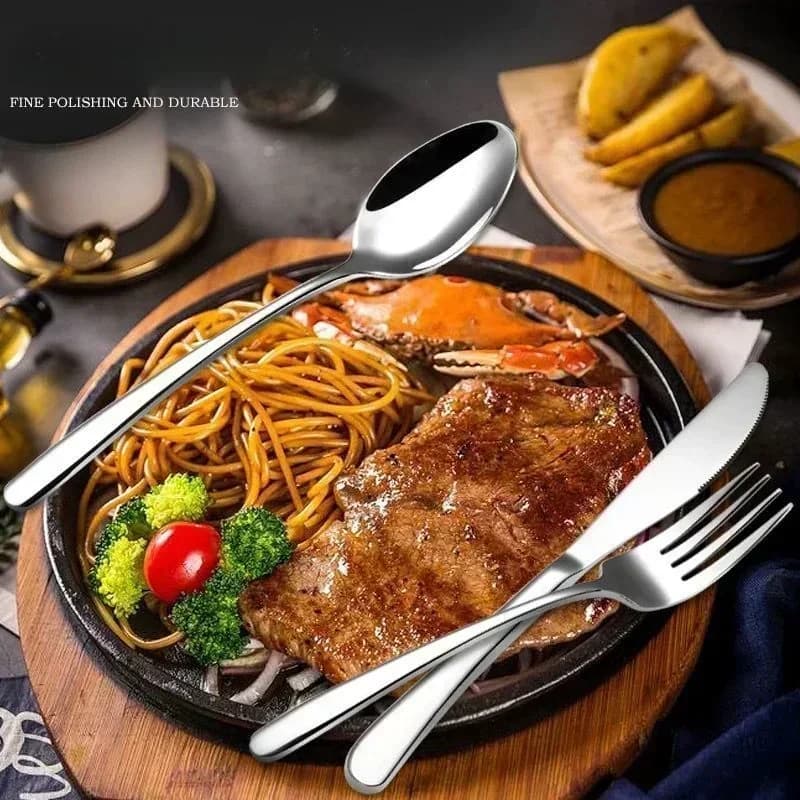 Talheres de aço inoxidável polidos usados para refeição com carne, macarrão e legumes