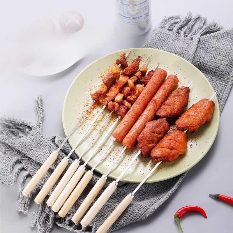 Espetos para churrasco Jácotei inox 304 com cabo de madeira, com carnes e linguiça na chapa