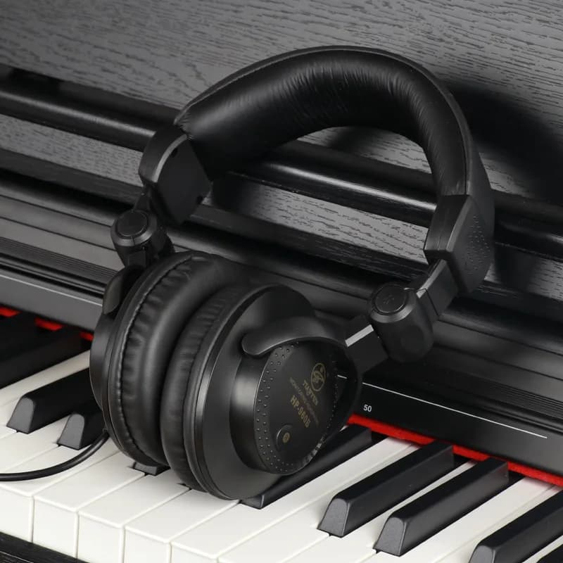 Fone de ouvido com fio HP-960B preto apoiado em teclado, estilo monitoramento ao vivo profissional