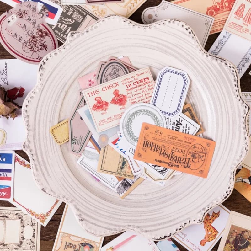 Prato branco com adesivos vintage para scrapbook em cores neutras e detalhes retrô variados
