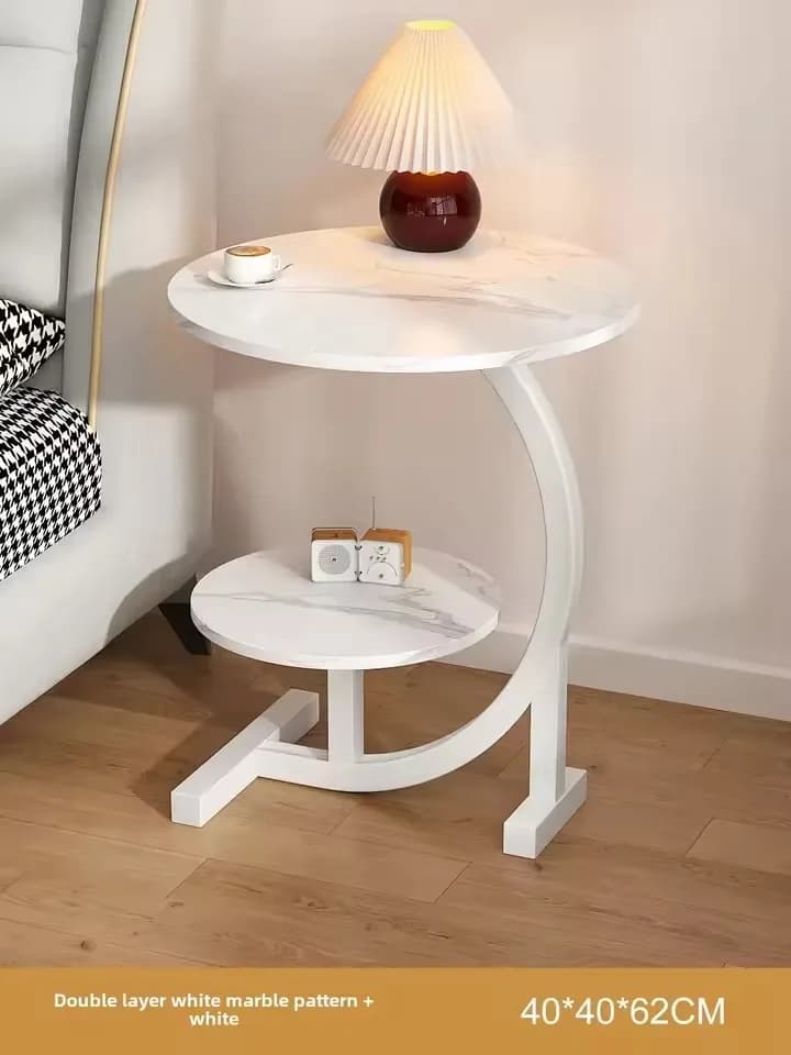 Mesa lateral minimalista branca com tampo redondo em mármore branco e base metálica para economia de espaço