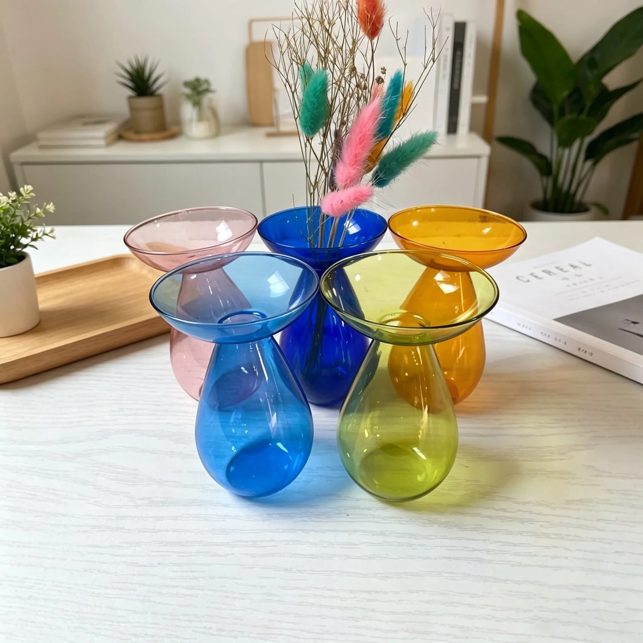 Vasos de vidro colorido em forma de abacate em uma prateleira branca