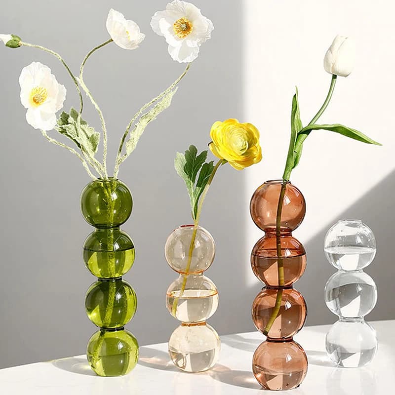 Vasos esféricos de vidro transparente com flores artificiais verde, transparente e marrom