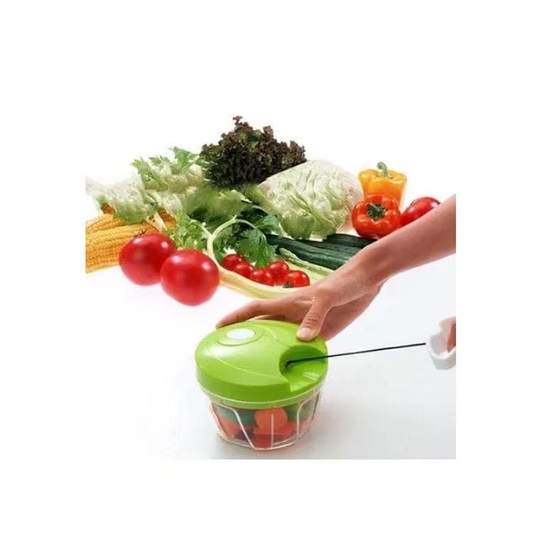 Processador manual de alimentos verde para triturar, picar e cortar temperos com vegetais ao fundo
