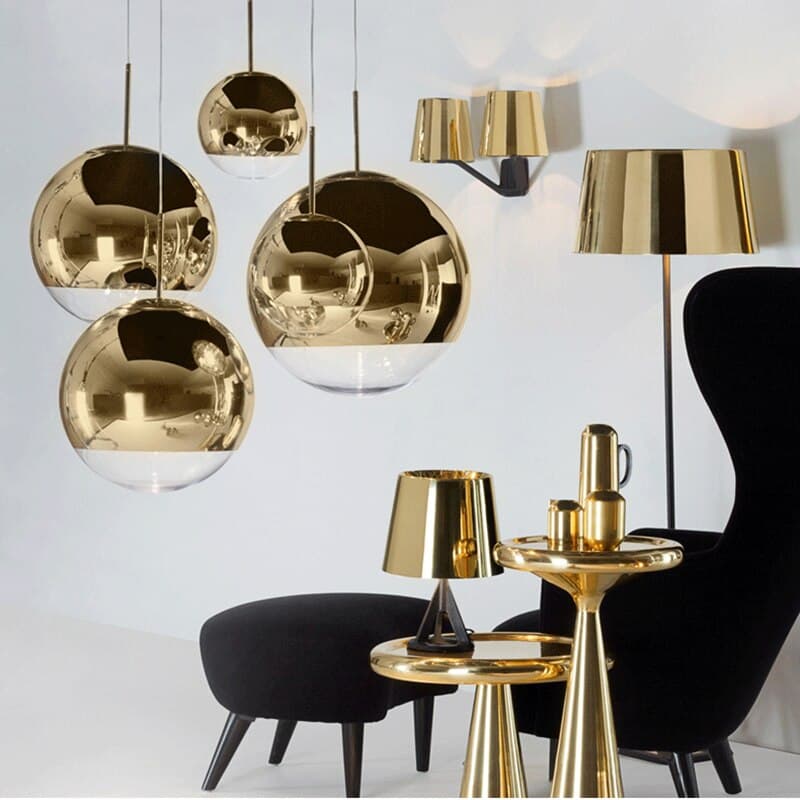 Lustres pendentes de metal dourado com cúpulas de vidro transparente em um ambiente elegante