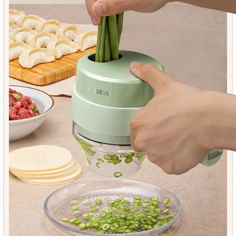 Triturador elétrico multifuncional verde cortando cebolinhas em um recipiente transparente