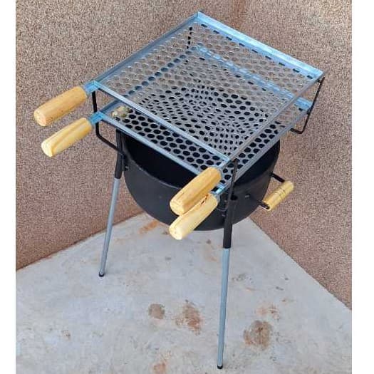 Churrasqueira portátil com grelha de carvão, dois níveis, alças de madeira, fundo de tijolos, chão de concreto