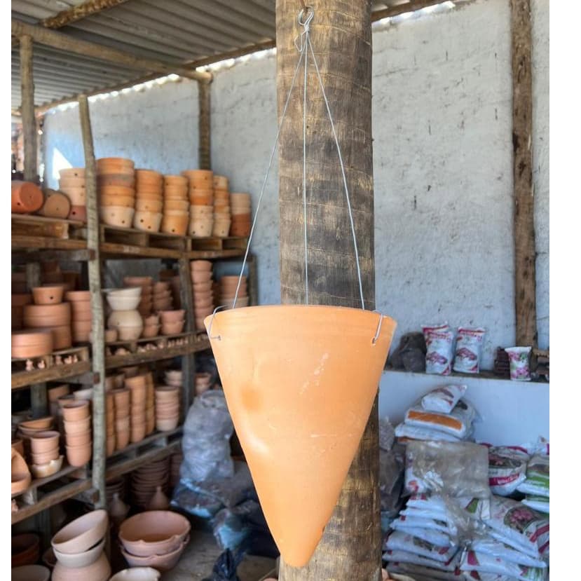 Vaso de cerâmica em forma de cone laranja para plantas em uma oficina
