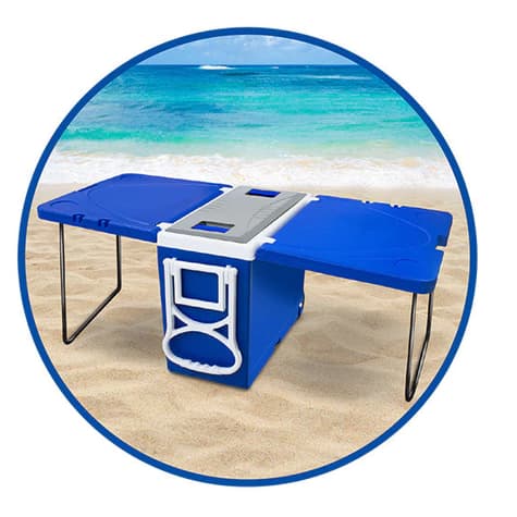 Caixa térmica multifuncional azul e cinza com duas mesas e cooler de 32 litros na praia.