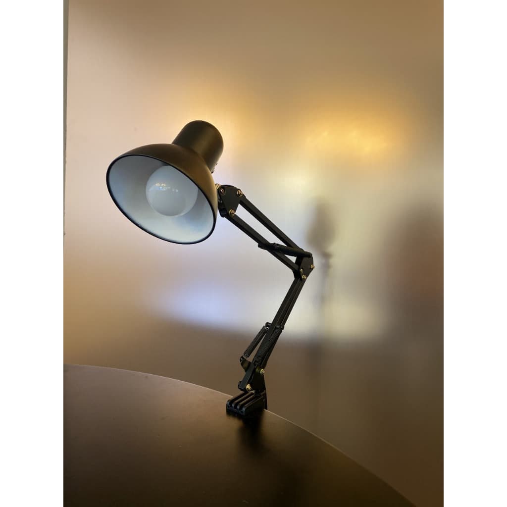 Luminária de mesa articulada preta com luz acesa