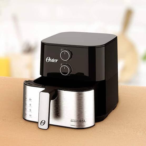 Fritadeira elétrica sem óleo Oster 1500W 4,6 litros, preta e prata, com controles rotativos.