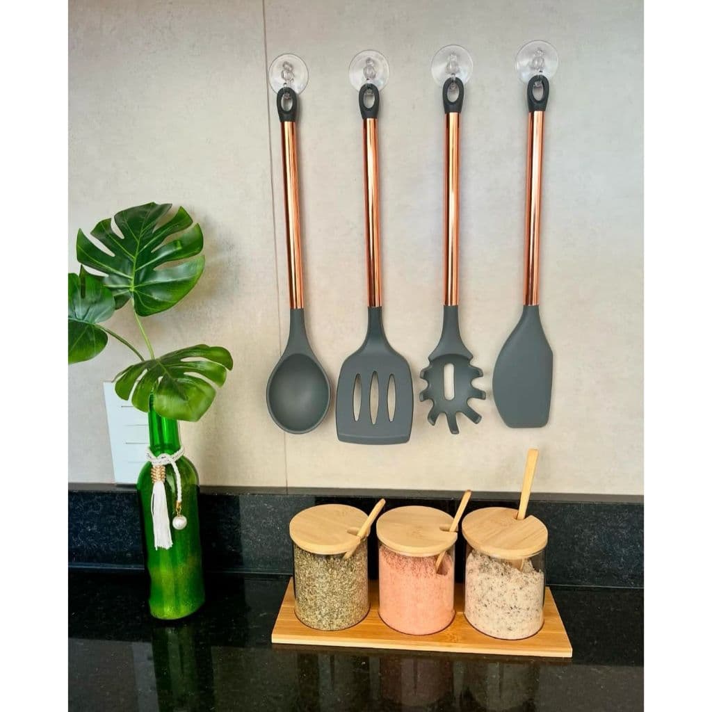 Utensílios de cozinha com cabos inoxidáveis rose gold montados em suporte de parede