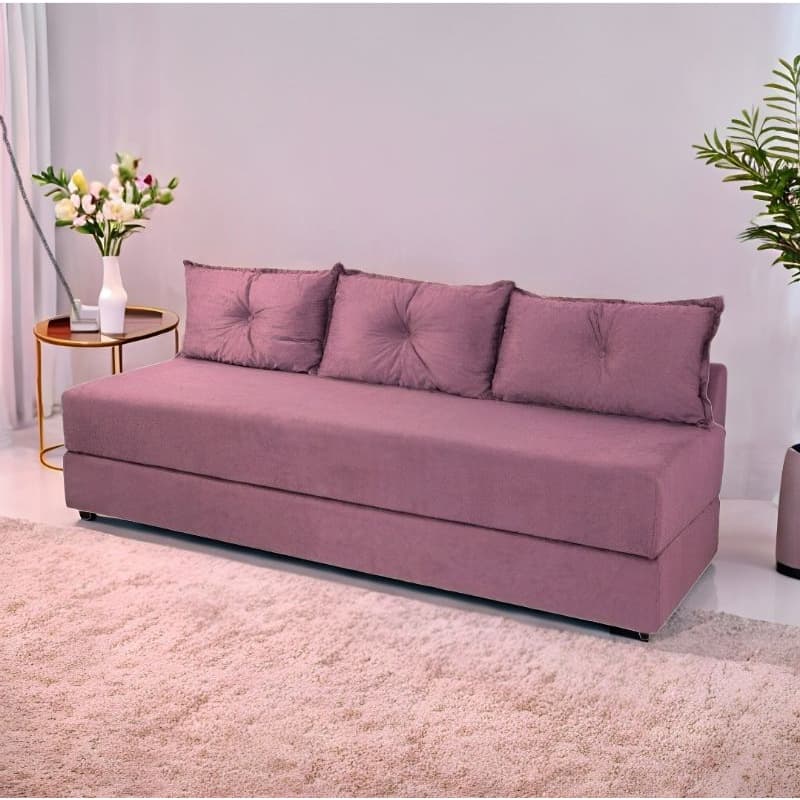 Sofá-cama rosa claro com quatro almofadas em ambiente interno