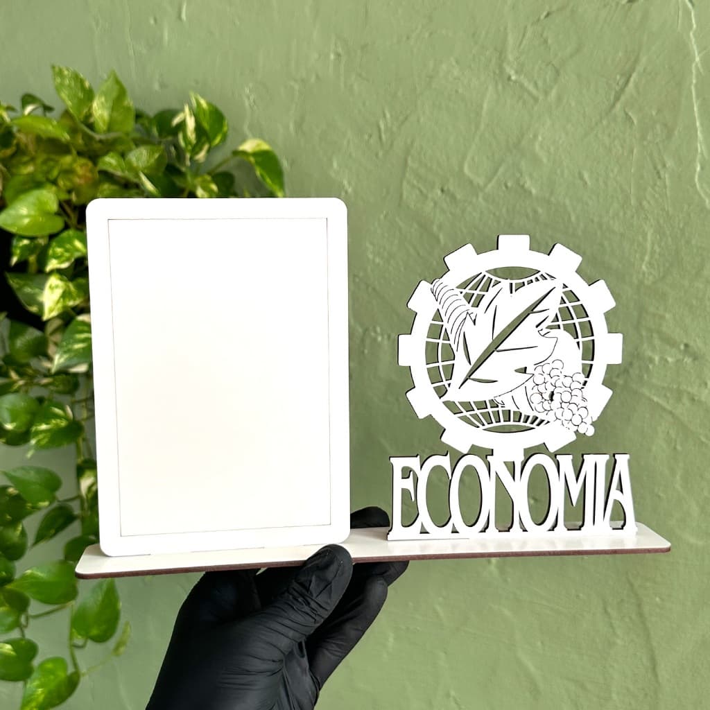 Porta-retrato em MDF branco com desenho de engrenagem e folhas, palavra 'ECONOMIA' abaixo, fundo verde com planta
