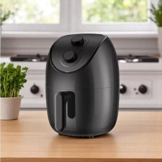 Fritadeira airfryer preta em uma cozinha moderna com fundo de planta e placa de gás