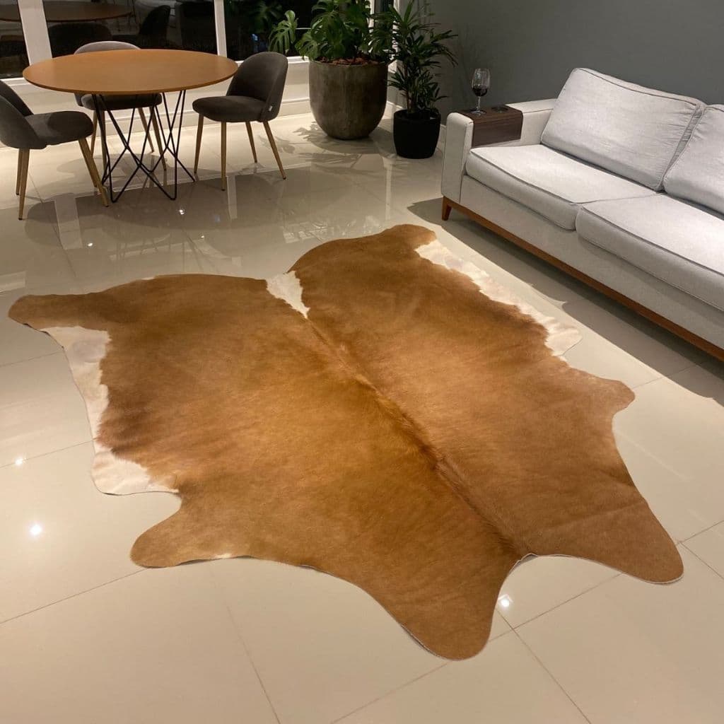 Tapete de couro legítimo grande em sala de estar com piso de azulejos claros e mobiliário moderno.