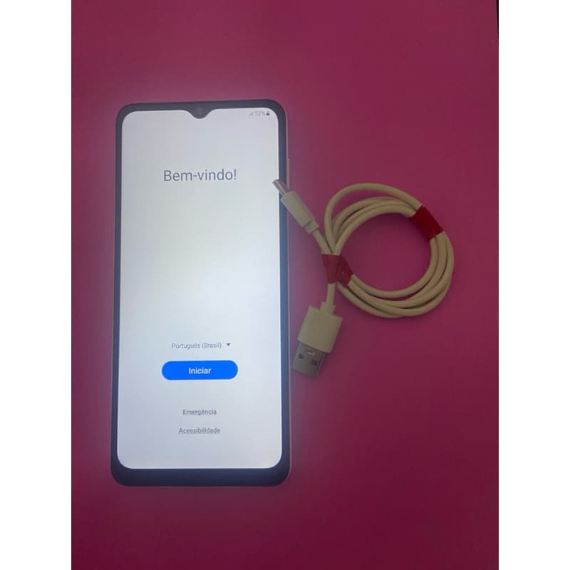 Samsung Galaxy A12 64 GB com cabo USB-C conectado, fundo rosa