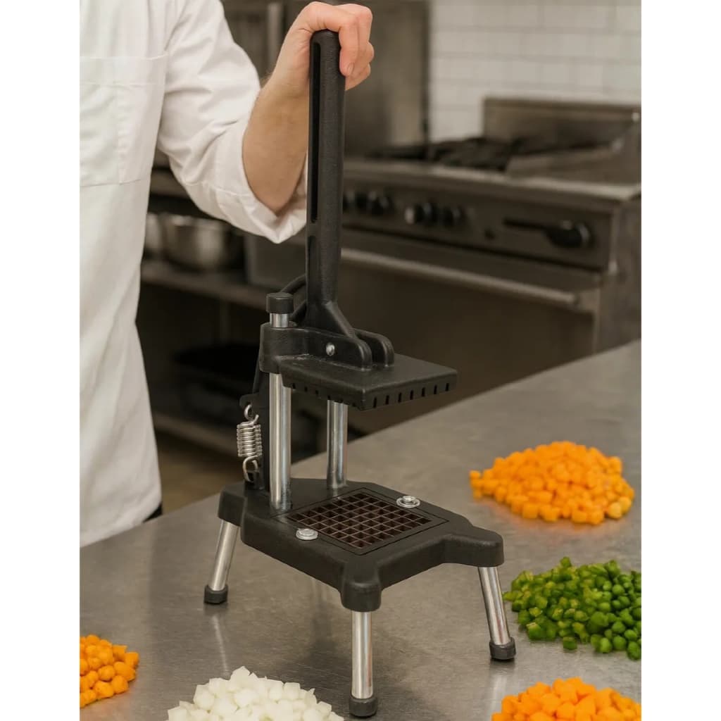 Picador de legumes industrial em uso, cortando cenoura e ervilha em uma cozinha.