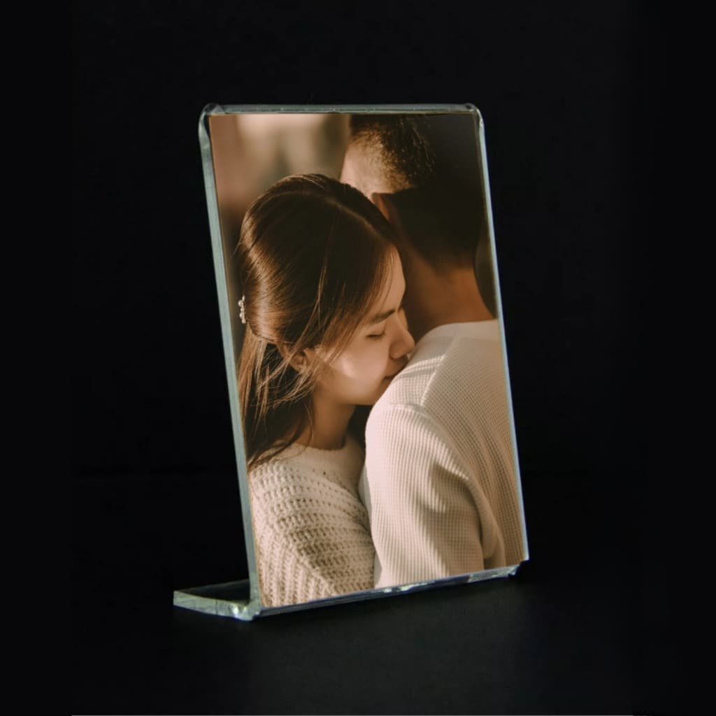 Porta retrato acrílico transparente com foto de casal abraçado.