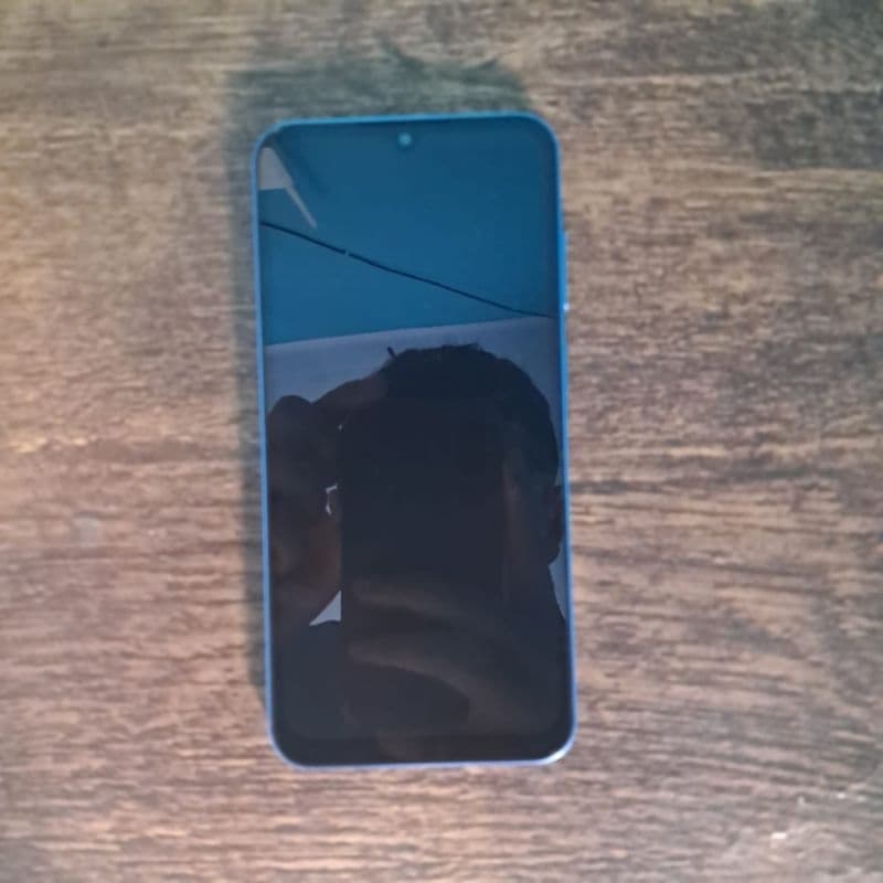 Smartphone Samsung Galaxy A25 5G em fundo de madeira, cor azul, tela desligada