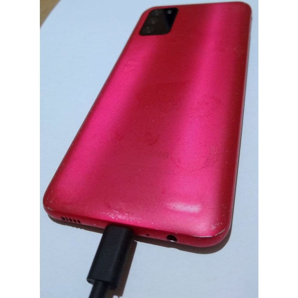 Visão traseira do Samsung Galaxy A03s rosa conectado a carregador