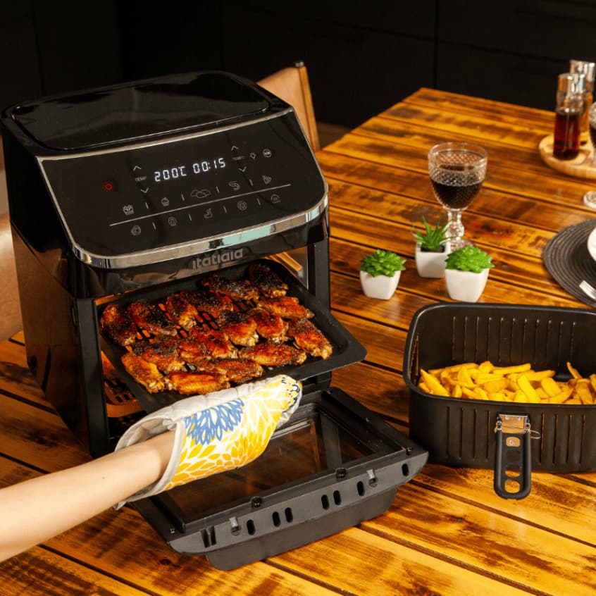 Air Fryer 12L Itatiaia 127V em uso com asas de frango e batatas fritas