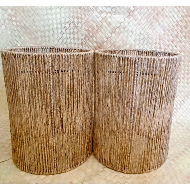 Dois abajures rústicos cilíndricos de sisal sobre superfície de palha.