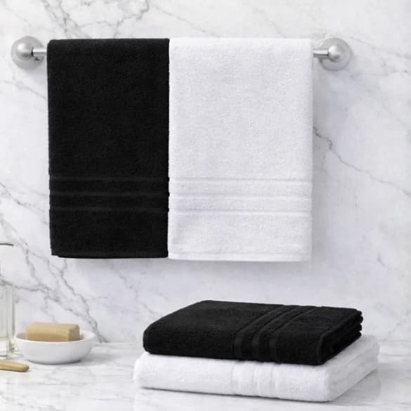 Kit toalha de banho e rosto 100% algodão, preto e branco, penduradas e empilhadas