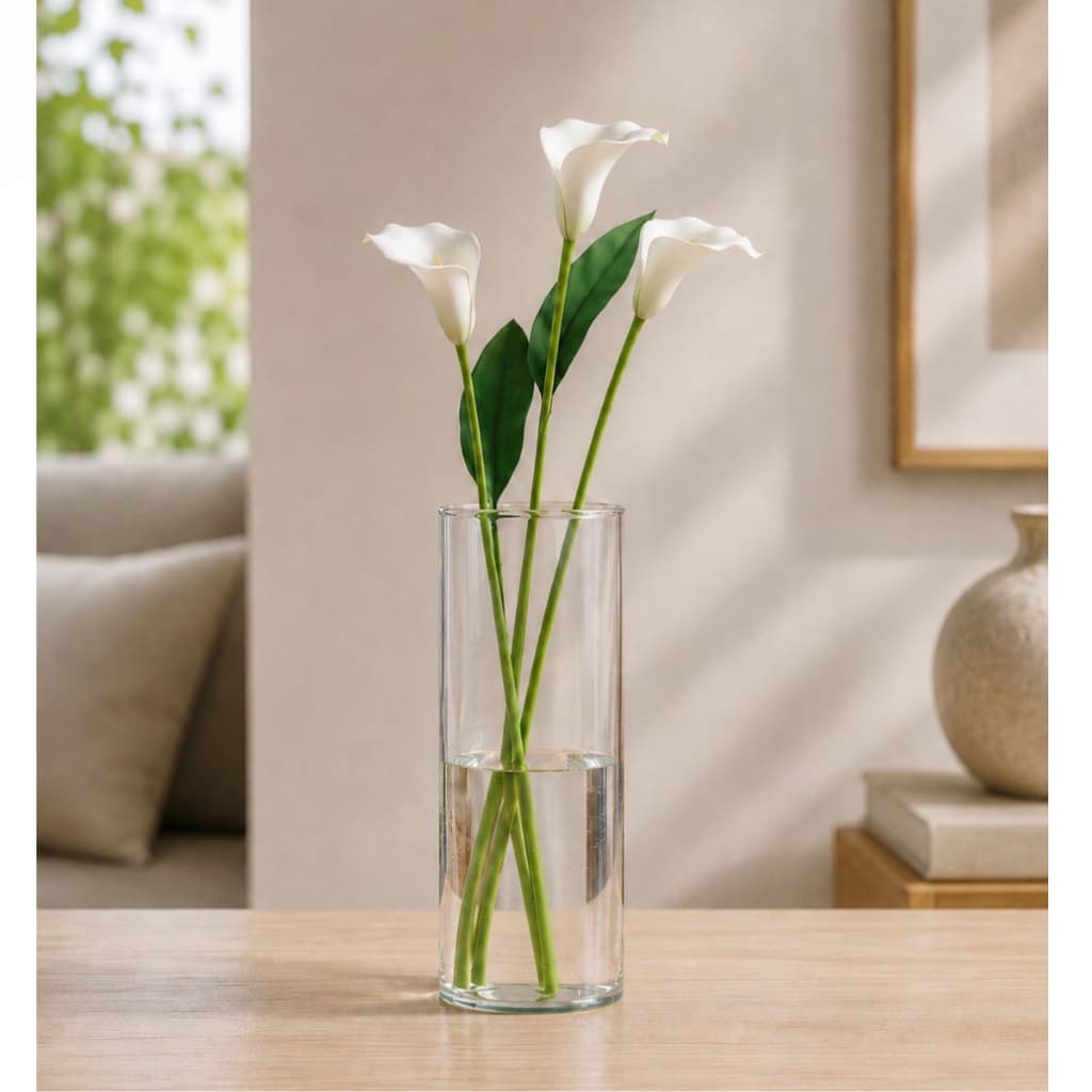 Vaso cilíndrico transparente com flores brancas e folhas verdes