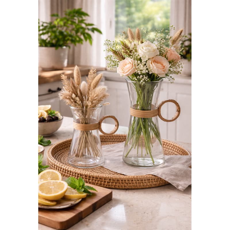 Vasos de vidro com fibra natural e rattan com flores e folhagens dentro, sobre uma bandeja de vime.