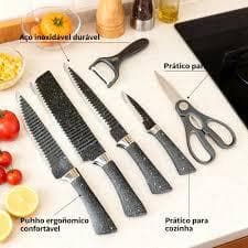 Sete facas de cozinha com cabo preto e lâminas de aço inoxidável, incluindo faca chef, cutelo, faca para trinchar, faca para descascar e tesoura, dispostas sobre uma superfície de cozinha.
