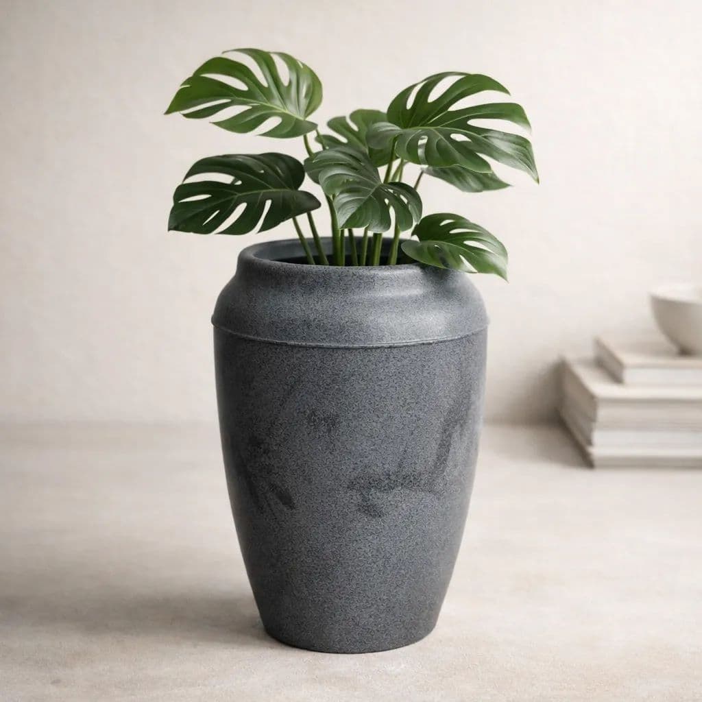 Vaso cinza texturizado com planta verde em fundo neutro
