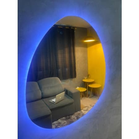Espelho decorativo abstrato com LED orgânico, moldura oval, iluminação azul, ambiente moderno.