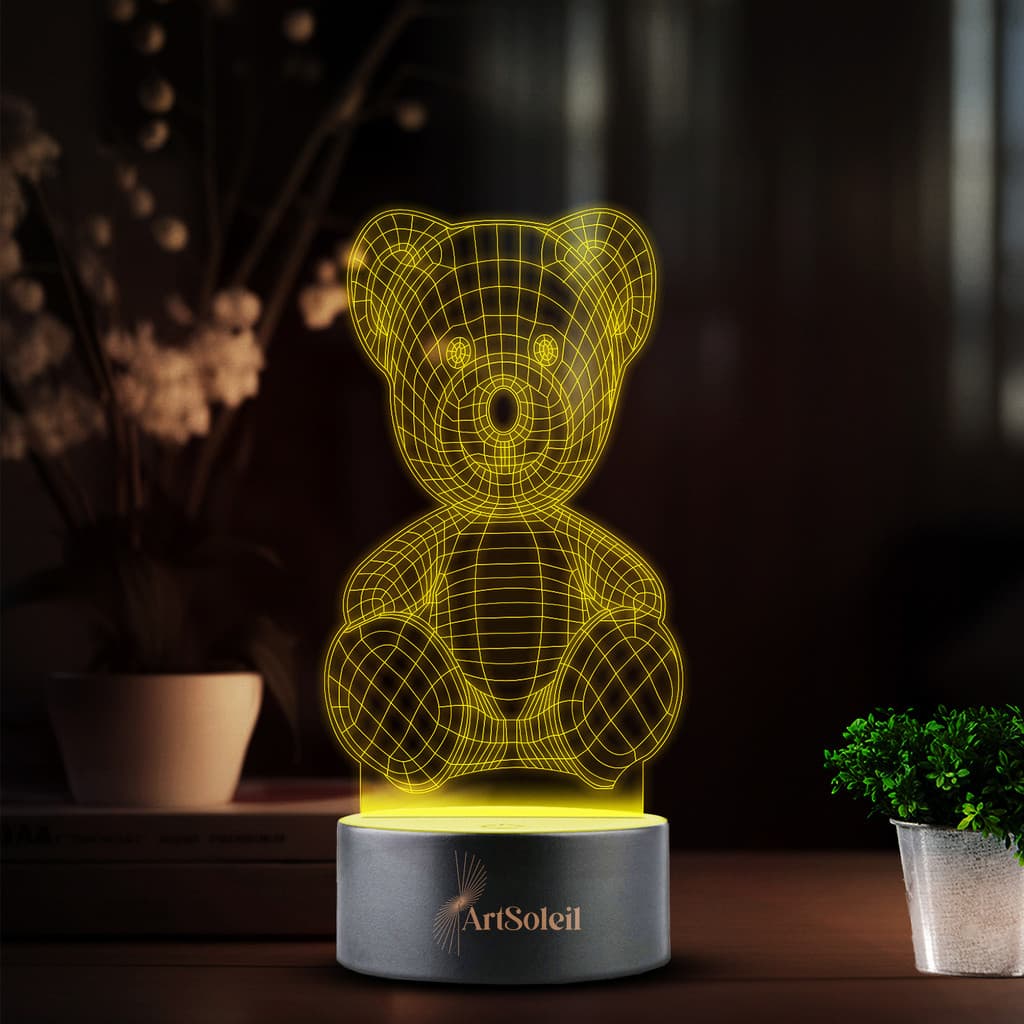 Luminária LED 3D de mesa em forma de urso, amarela, com base cinza e texto 'ArtSolei'.