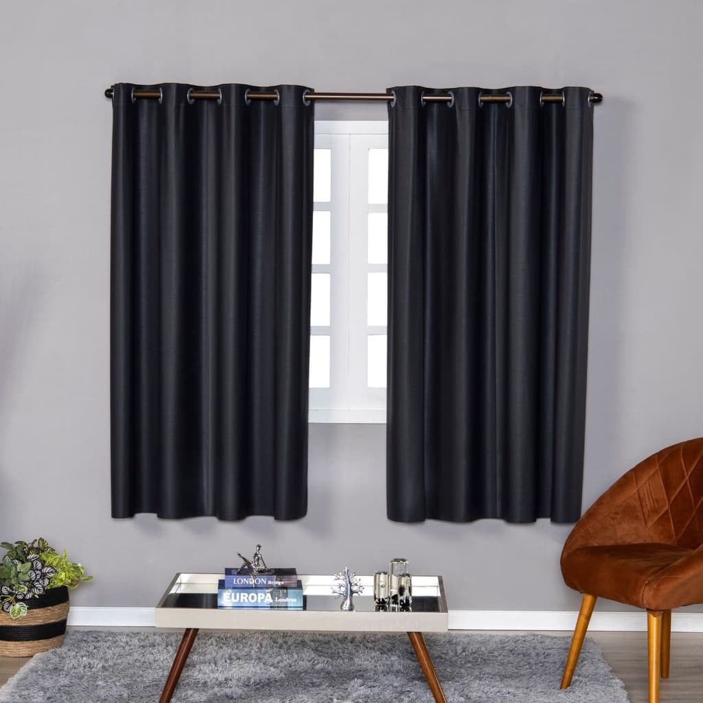 Cortinas pretas blackout de PVC presas a um varão, cobrindo a janela em um ambiente de sala de estar.