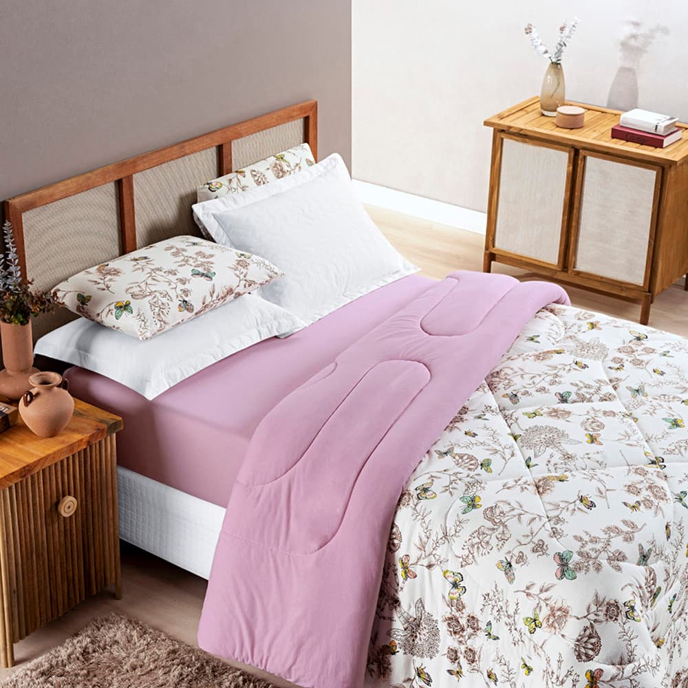 Edredom estampado de flores lilás e branco sobre cama de solteiro
