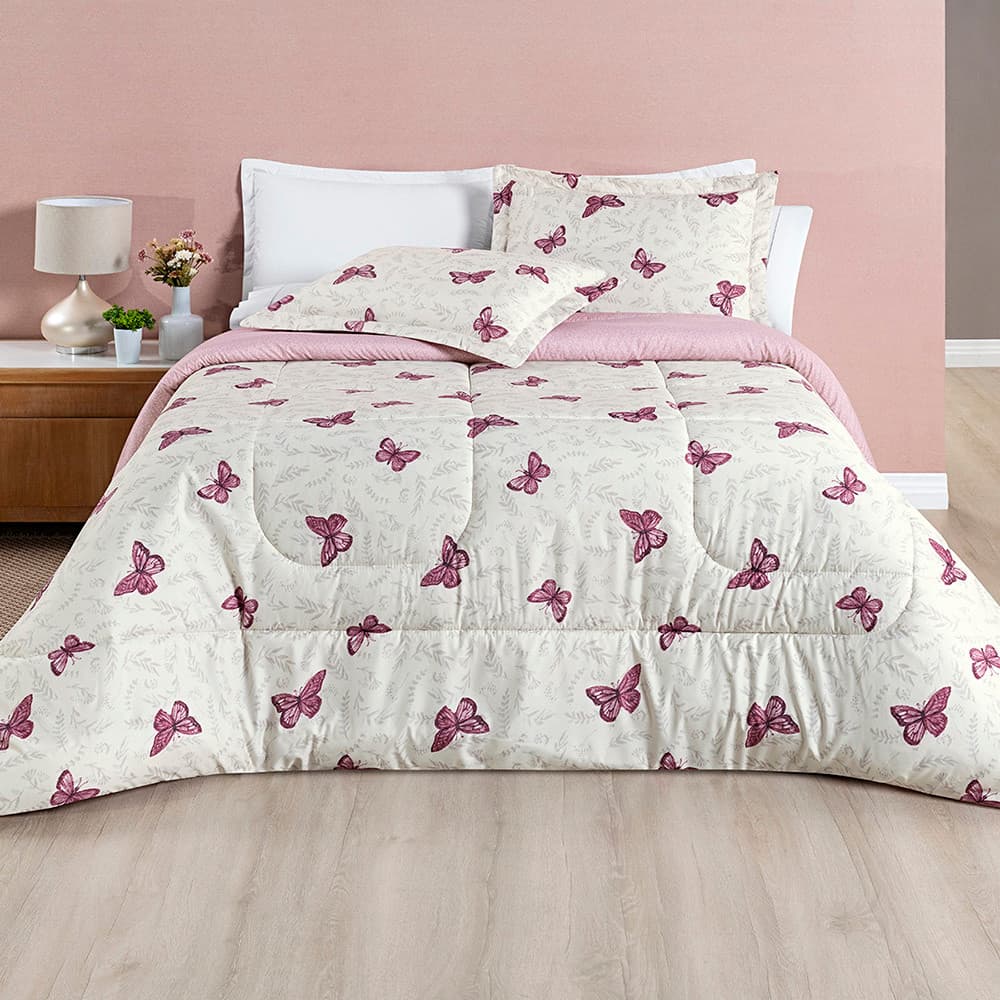 Edredom com estampa de borboletas rosa em fundo branco, cobrindo uma cama de super king.
