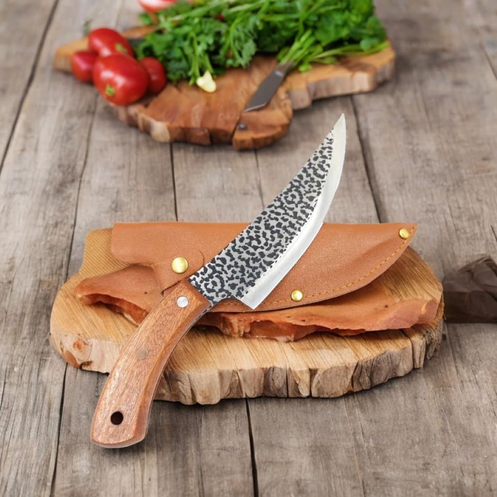 Faca artesanal de cozinha churrasco desossa forjada à mão com cabo de madeira e bainha de couro sobre um corte de madeira