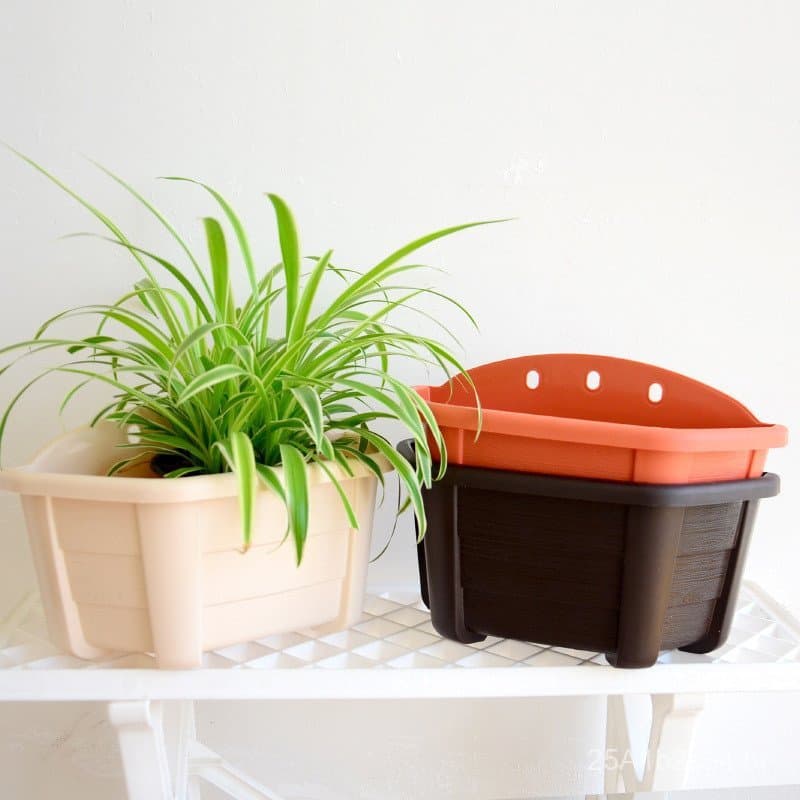 Vasos suspensos rosa e preto com tampa laranja para plantas