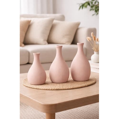 Trio de vasos decorativos de cerâmica rosa em um centro de mesa marrom