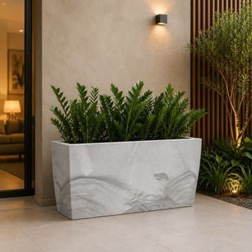 Jardineira grande cinza com plantas verdes, ideal para ambientes externos.