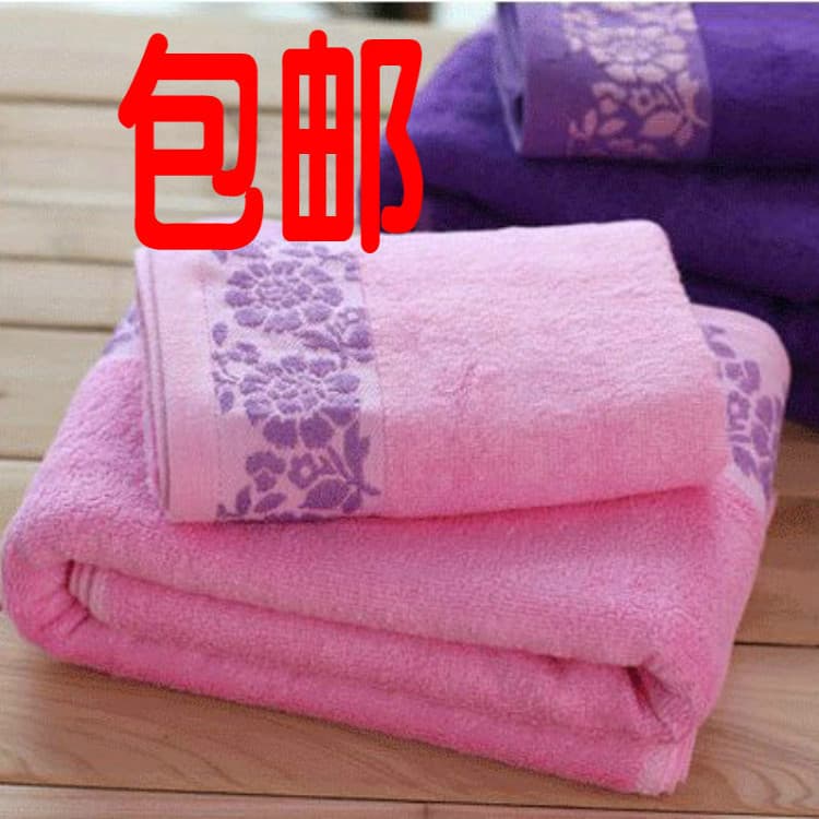Toalhas de banho de fibra de bambu Jacquard com padrão floral, cor predominante rosa, sobre fundo de madeira.