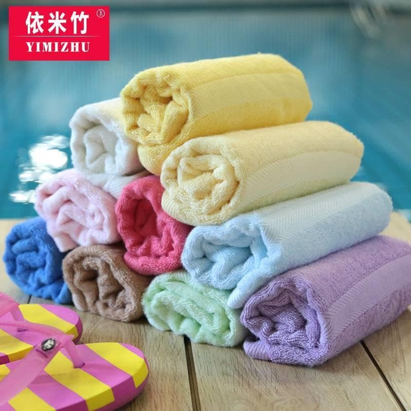 Toalhas de bambu em cores pastel, pilha em fundo azul, marca YIMIZHU, sandália rosa e amarela