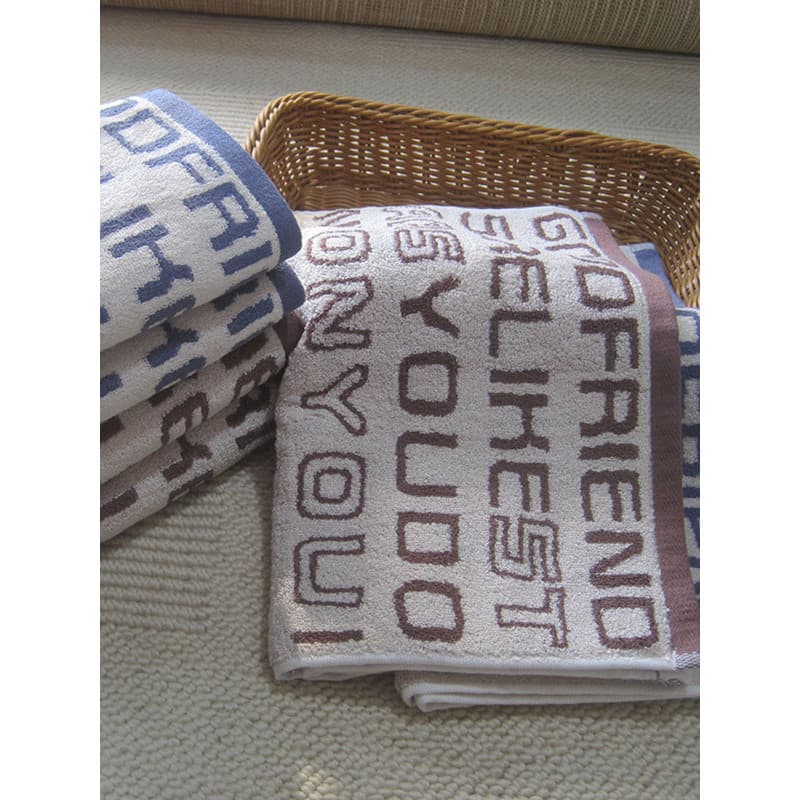 Toalha de banho branca com padrão Jacquard e texto 'YOUR FRIEND' em azul e marrom
