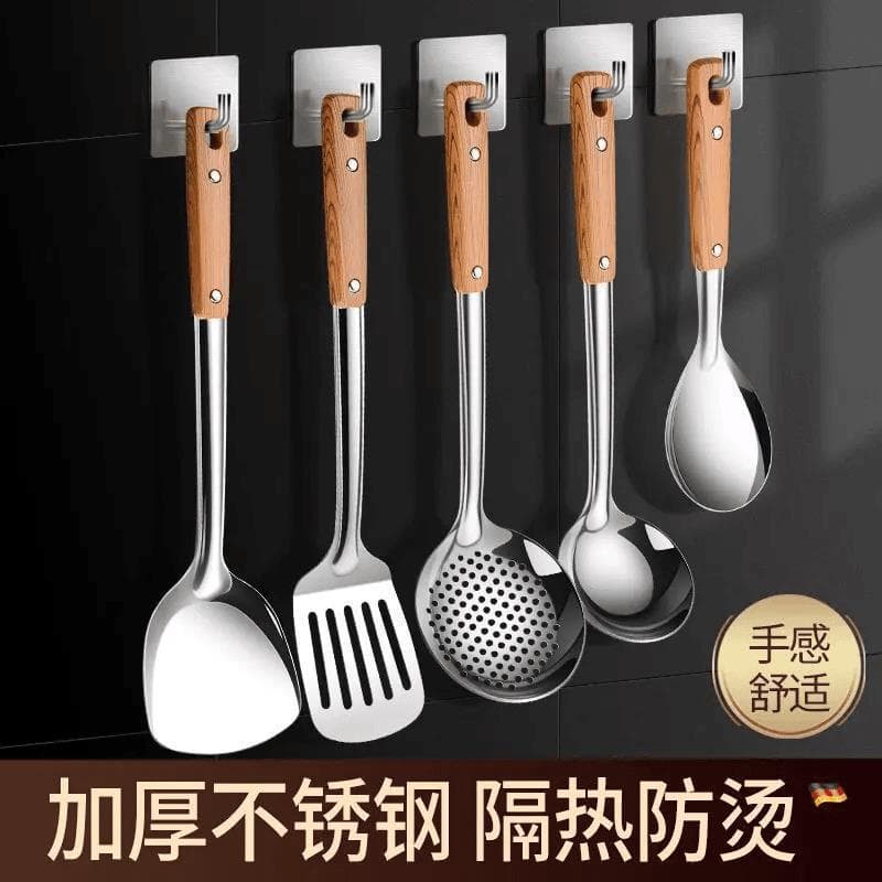 Utensílios de cozinha de aço inoxidável com cabos de madeira pendurados em suporte de parede
