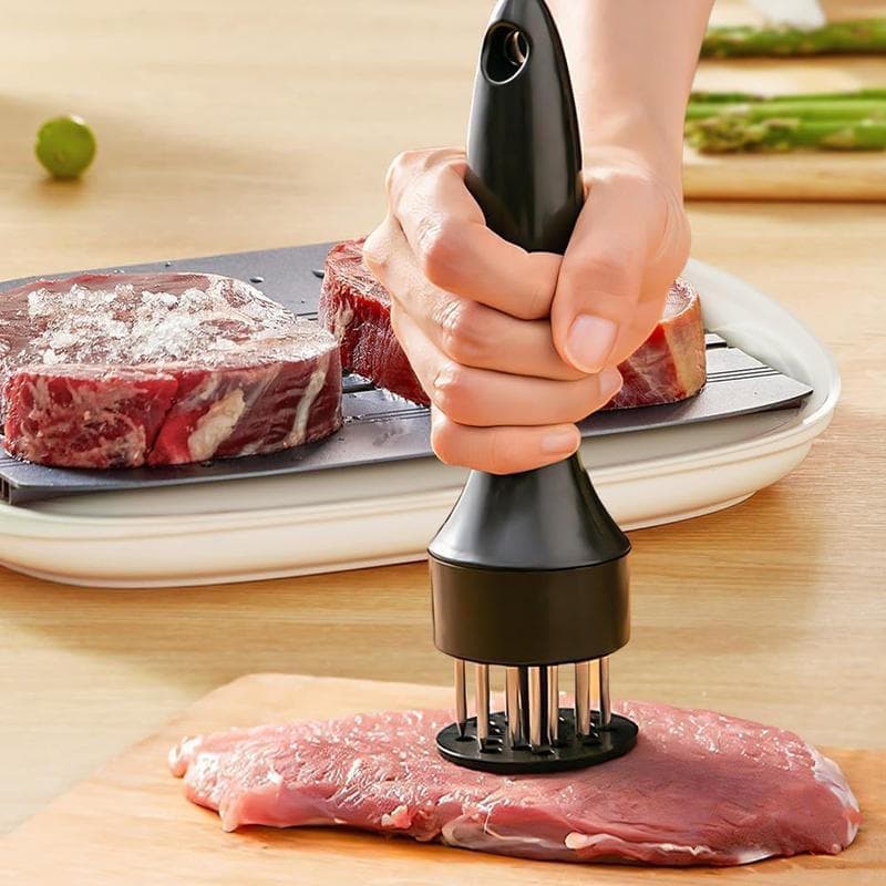 Amaciador de carne em aço inoxidável sendo usado para amaciar carne